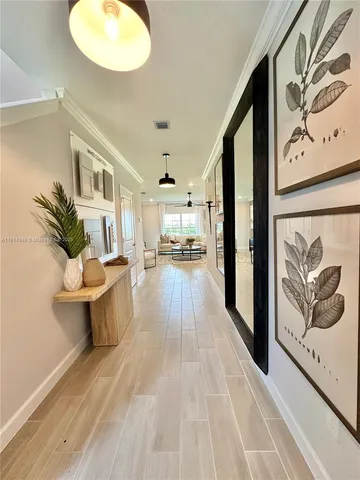 a view of a hallway with wooden floor and furniture