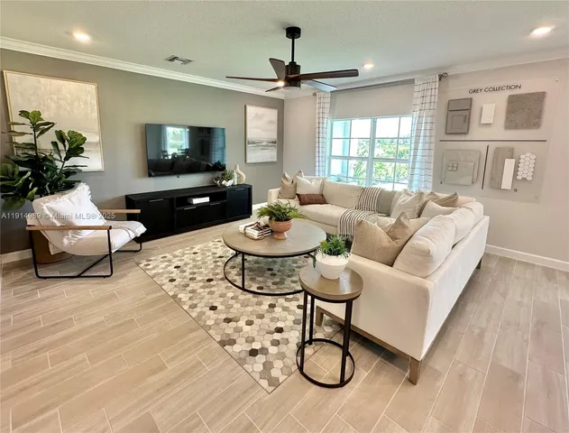 a living room with furniture a flat screen tv and a table