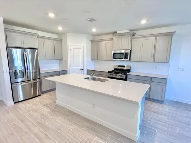 a kitchen with stainless steel appliances a refrigerator sink and microwave