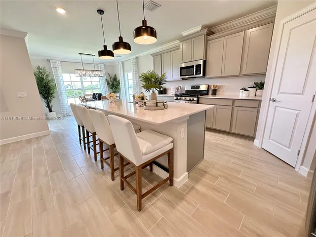 a kitchen with granite countertop a table chairs microwave and cabinets
