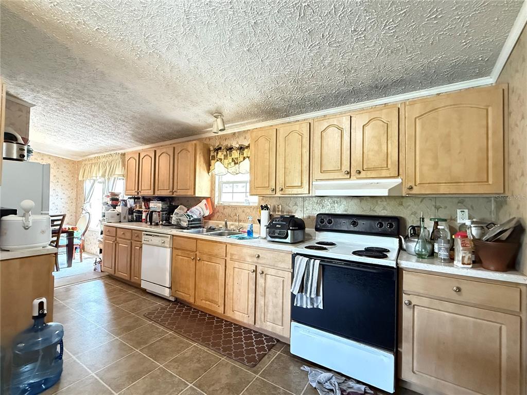 11101 Sumner Road Wimauma, FL 33598 - Photo 12 of 22 a kitchen with granite countertop a stove sink and cabinets