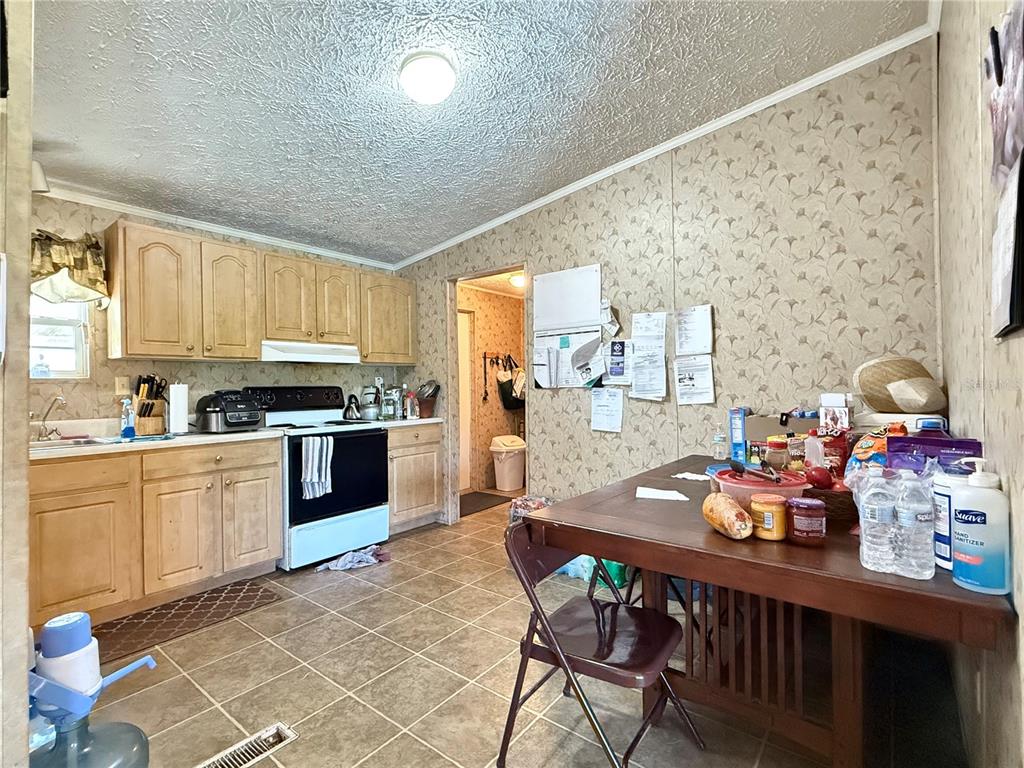 11101 Sumner Road Wimauma, FL 33598 - Photo 13 of 22 a kitchen with granite countertop a sink cabinets and stainless steel appliances