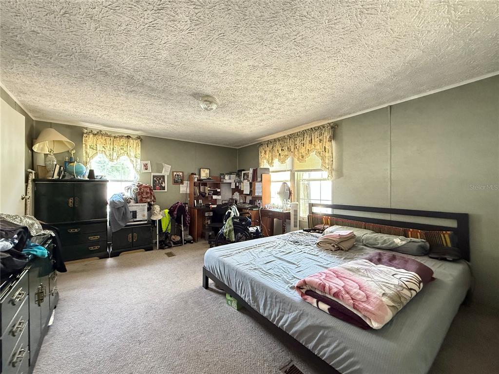 11101 Sumner Road Wimauma, FL 33598 - Photo 14 of 22 a bedroom with a bed and a flat tv screen on dresser