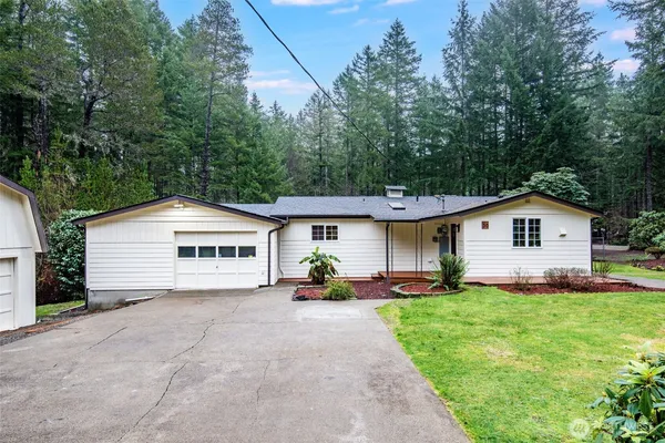 a view of a house with a yard and large trees