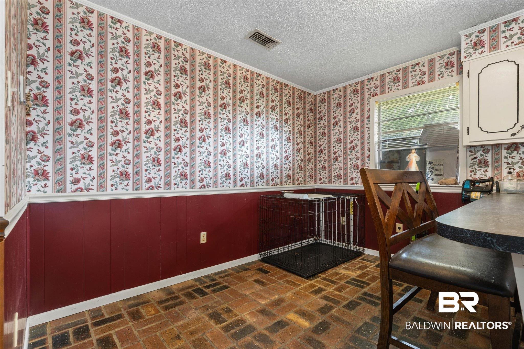 11601 Lott Road Chunchula, AL 36521 - Photo 5 of 34 Dining room with wallpapered walls, a wainscoted wall, a textured ceiling, brick floors, and crown molding