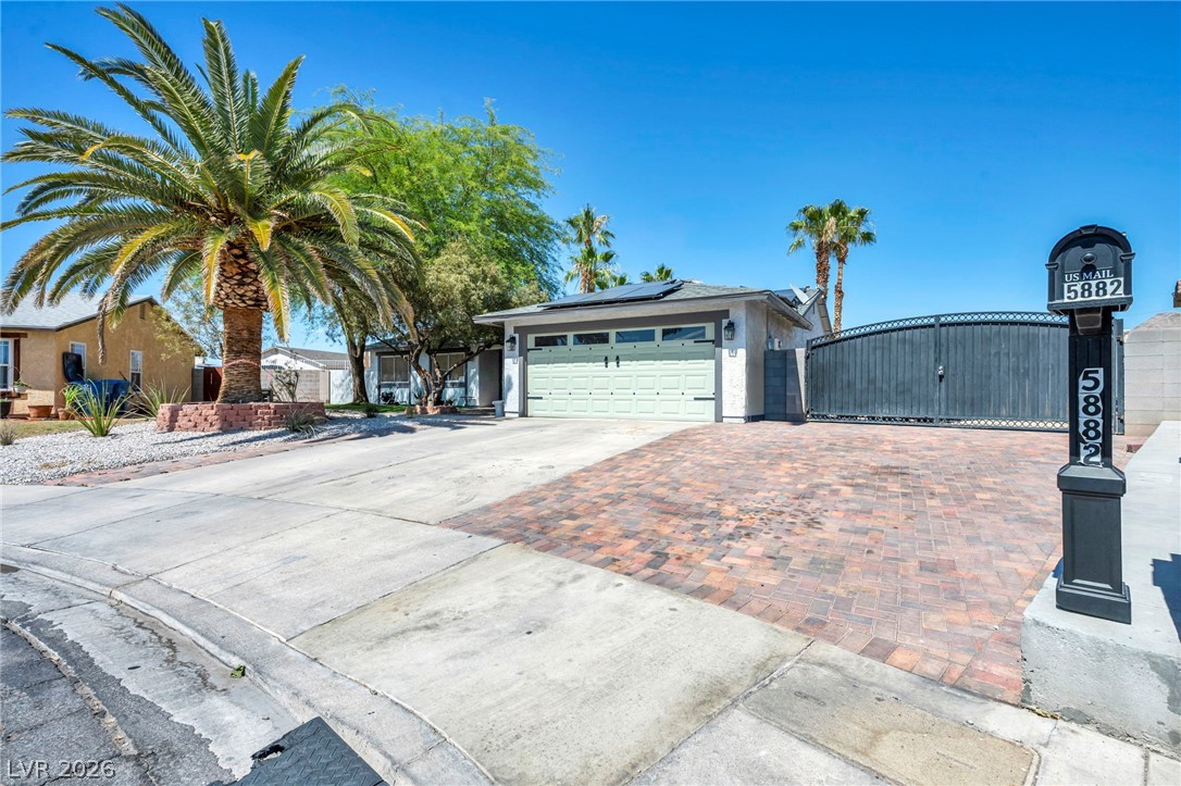 5882 Rio Tinto Way Las Vegas, NV 89110 - Photo 4 of 56 A neatly paved driveway leads to a welcoming residence, featuring a secure gated entrance.