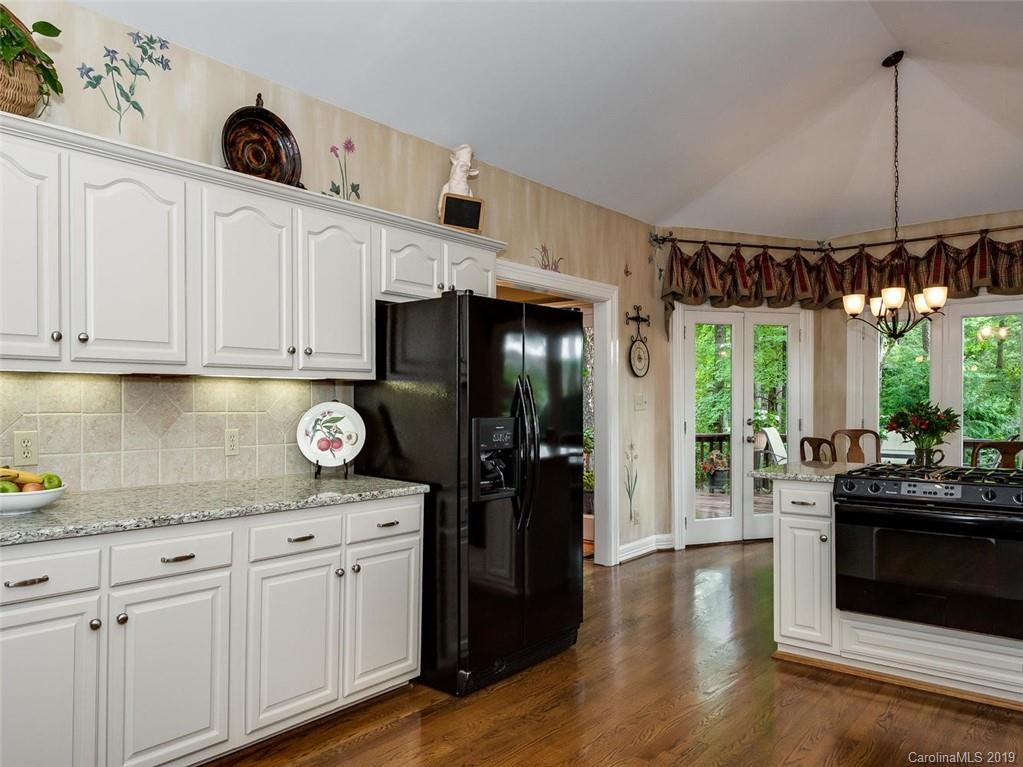 5123 Randolph Road Charlotte, NC 28211 - Photo 11 of 28 a kitchen with stainless steel appliances granite countertop a refrigerator a stove and a wooden floors