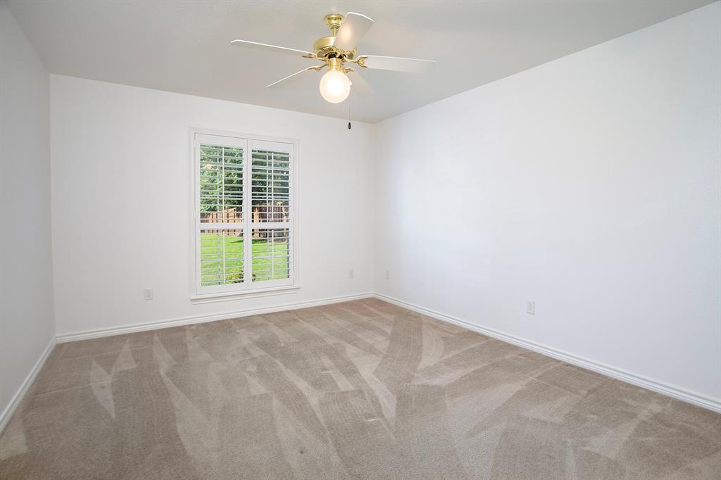 1521 Rice Road, Unit E105 Tyler, TX 75703 - Photo 18 of 29 an empty room with windows and fan