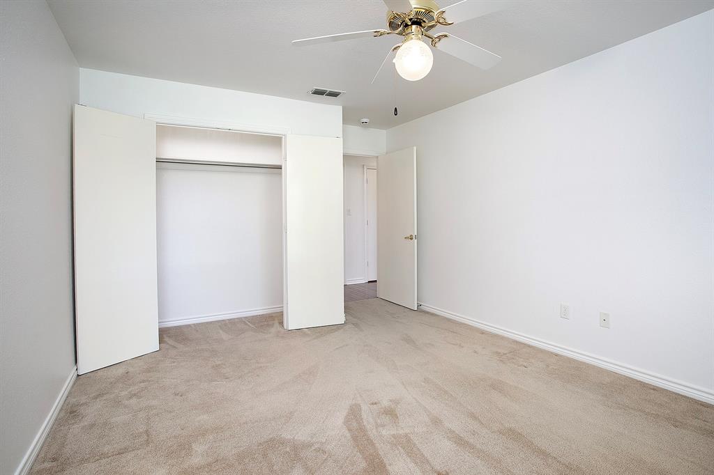 1521 Rice Road, Unit E105 Tyler, TX 75703 - Photo 19 of 29 an empty room with a fan and a fan