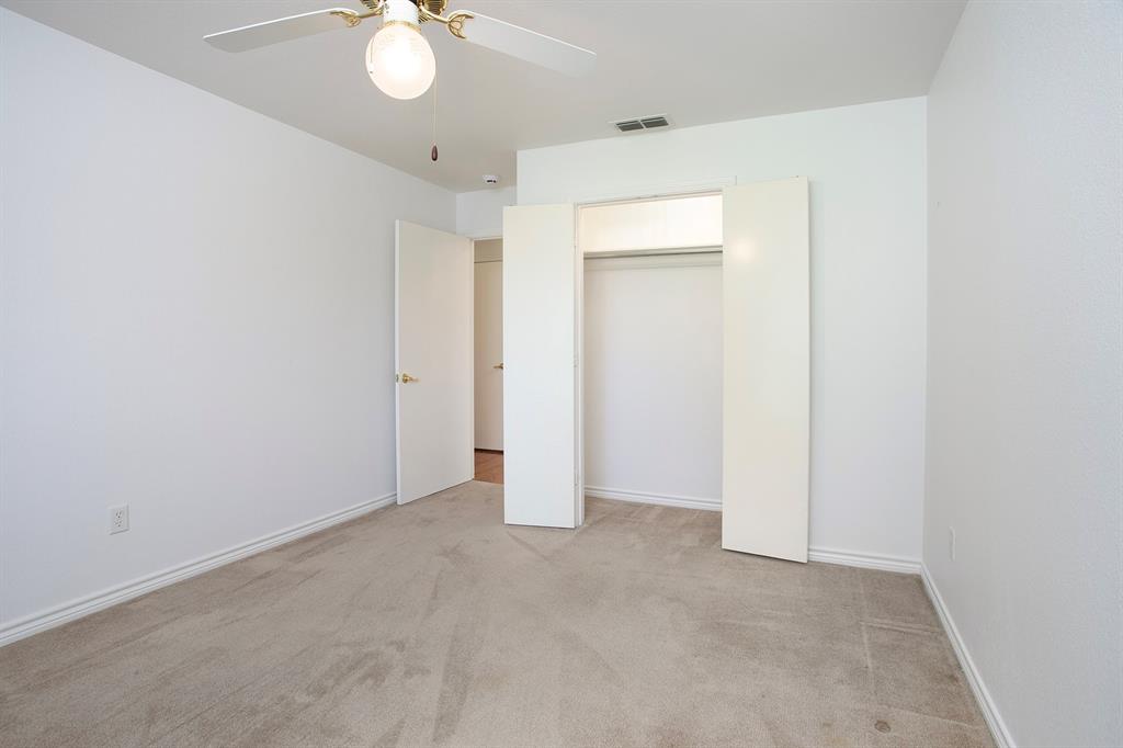 1521 Rice Road, Unit E105 Tyler, TX 75703 - Photo 21 of 29 an empty room with a chandelier fan and closet
