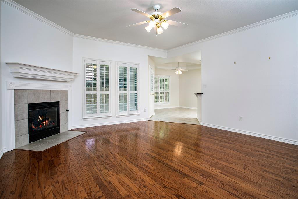 1521 Rice Road, Unit E105 Tyler, TX 75703 - Photo 7 of 29 a view of an empty room with wooden floor fireplace and a window