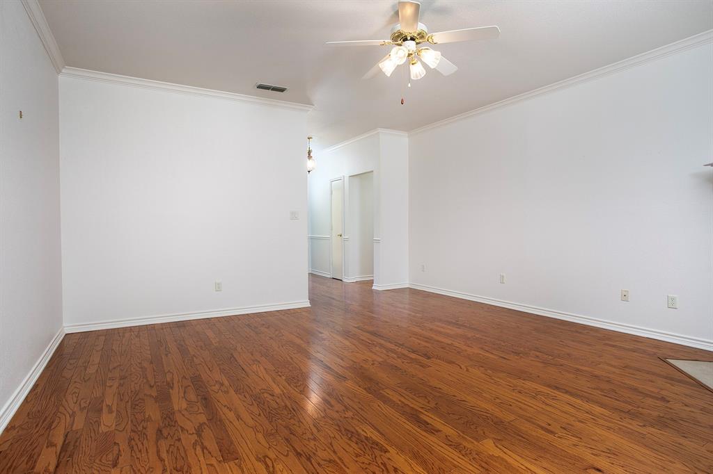 1521 Rice Road, Unit E105 Tyler, TX 75703 - Photo 8 of 29 an empty room with wooden floor and ceiling fan