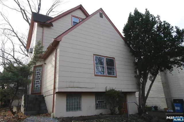 a front view of a house with a tree