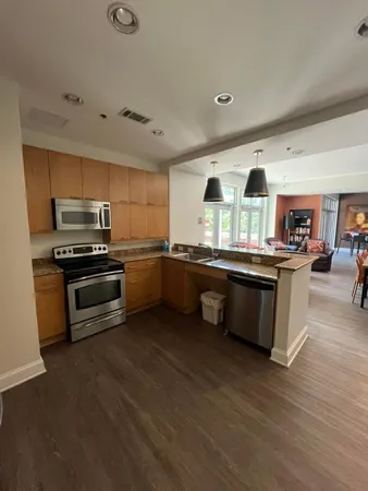 a kitchen with stainless steel appliances kitchen island granite countertop a stove a sink and a refrigerator