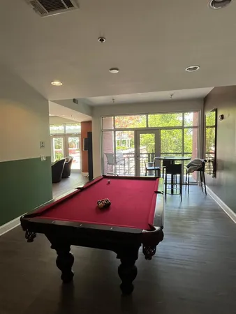 a room with pool table and windows