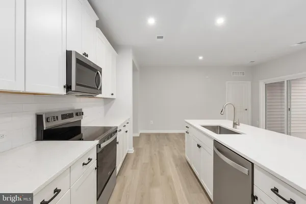 a kitchen with a sink a microwave and cabinets