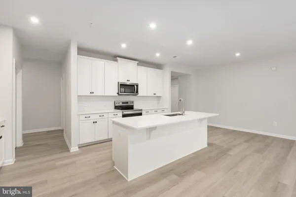 a kitchen with stainless steel appliances a white stove top oven sink and white cabinets