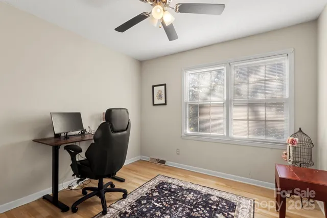 a view of a workspace with furniture and a window