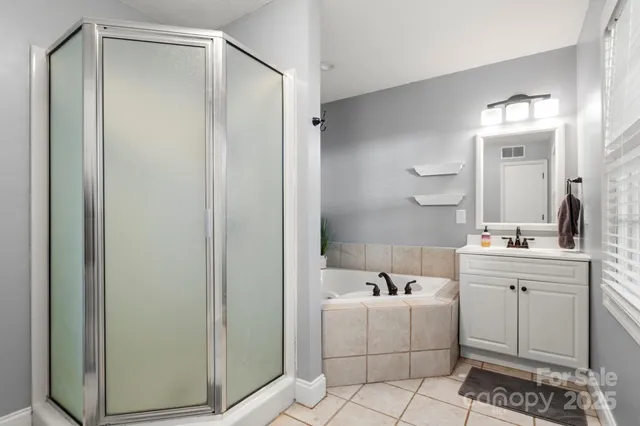 a bathroom with a bathtub a sink a vanity and a mirror