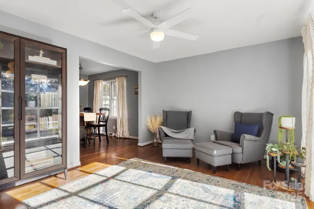 a living room with furniture a rug and white walls