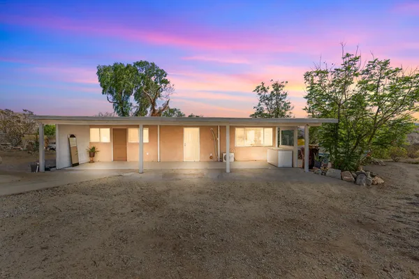a view of a house with a garden and a tree