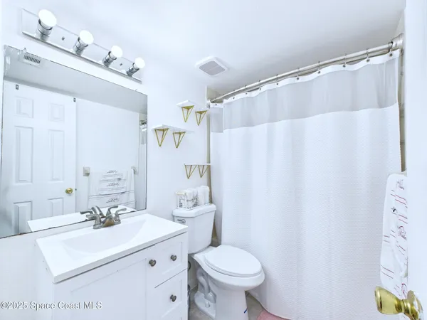 a bathroom with a sink a toilet and shower curtain