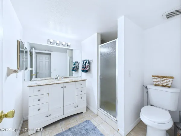 a bathroom with a granite countertop toilet sink and mirror
