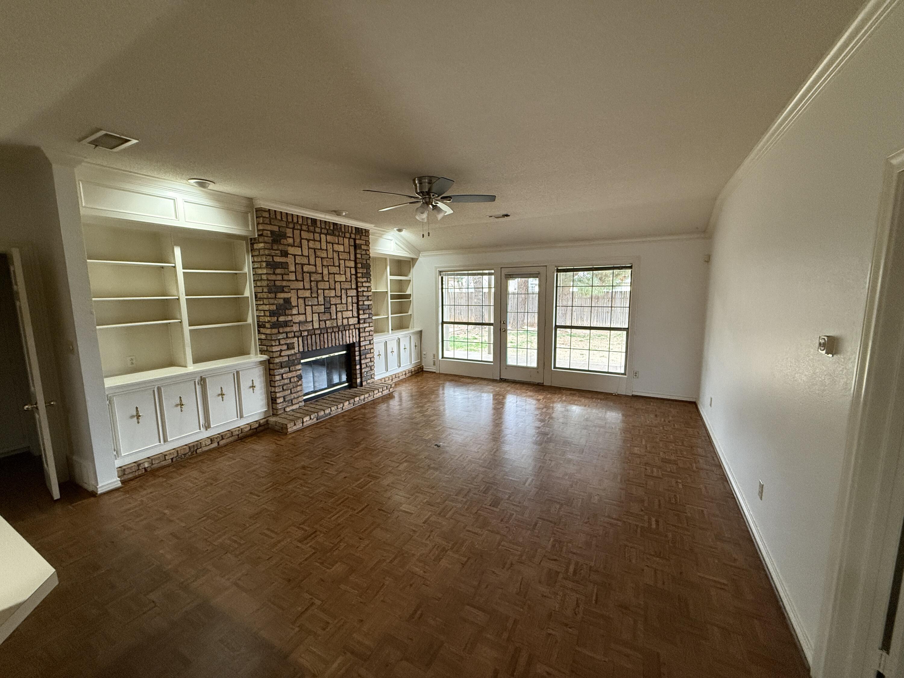 4828 11th Street Lubbock, TX 79416 - Photo 2 of 12 an empty room with fireplace and windows