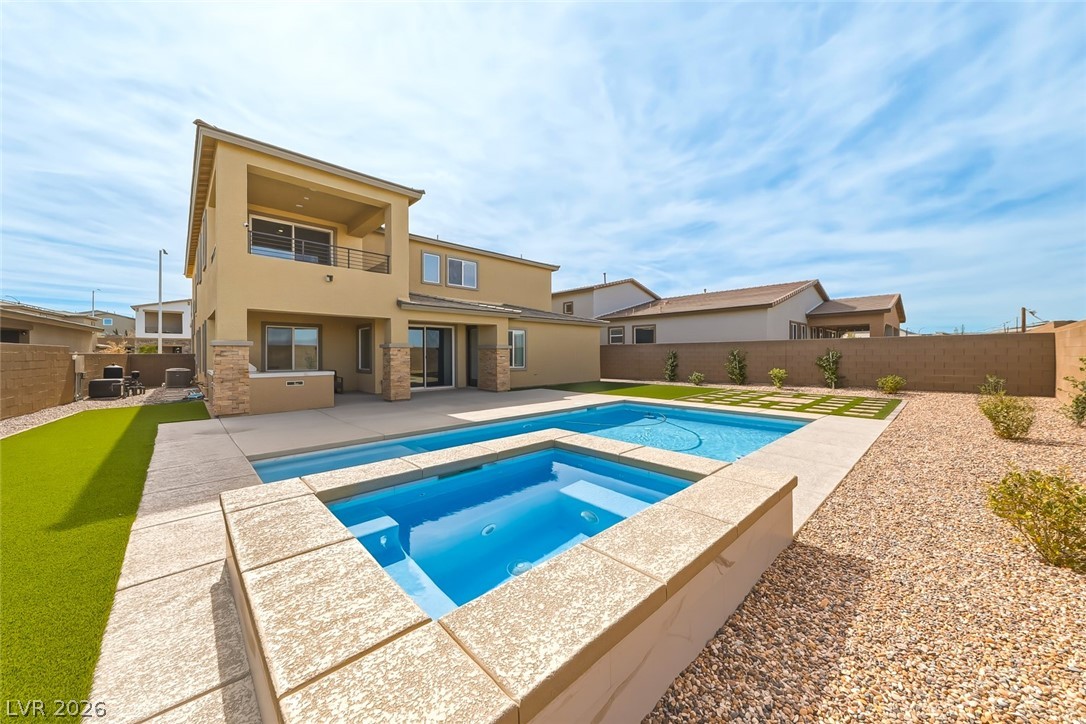 290 Rusty Ridge Lane Henderson, NV 89015 - Photo 40 of 61 Backyard w/pool & spa, desert rock w/synethic grass & pavers, built in outdoor kitchen w/fridge, cooktop & sink & No Rear Neighbors.