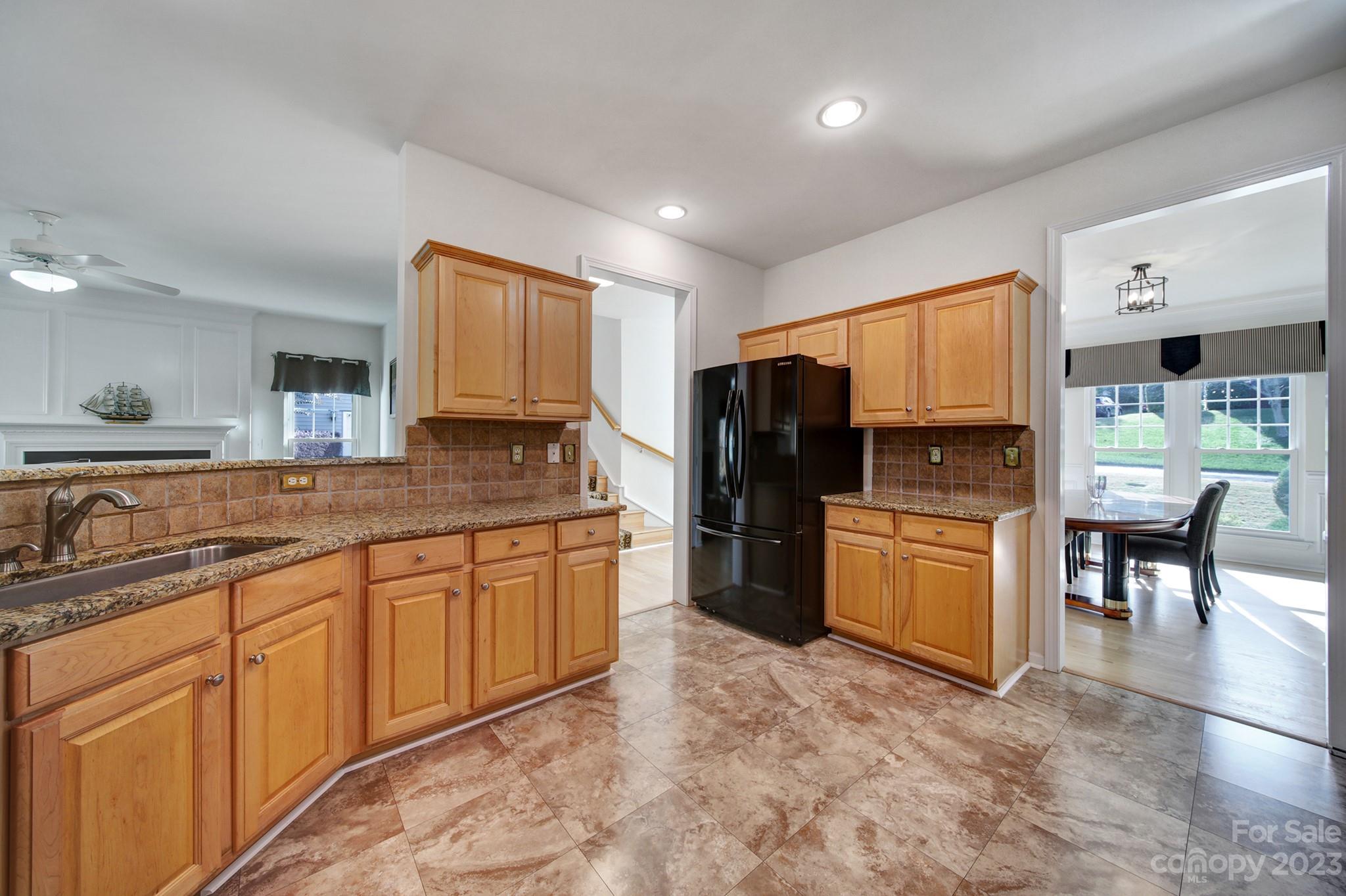701 Drew Avenue Fort Mill, SC 29708 - Photo 5 of 37 a large kitchen with stainless steel appliances granite countertop a refrigerator a stove a sink a dining table and chairs with wooden floor