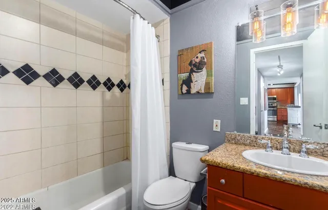 a bathroom with a granite countertop sink toilet and shower