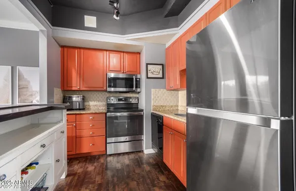a kitchen with stainless steel appliances a stove a sink and a refrigerator