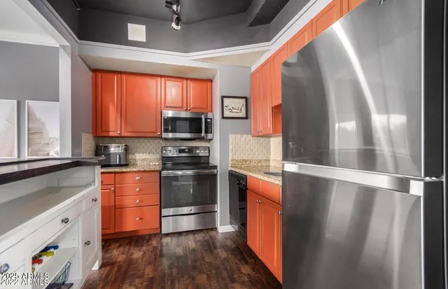 a kitchen with stainless steel appliances a stove a sink and a refrigerator