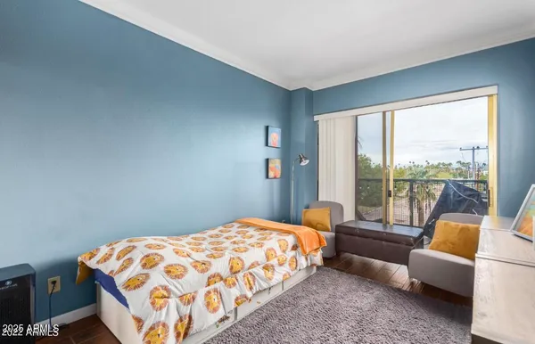 a bedroom with a bed and a couch next to a window