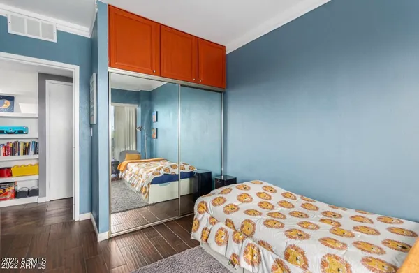a bedroom with natural light and wooden floor