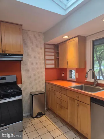 a kitchen with stainless steel appliances a sink stove and cabinets