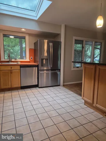 a kitchen with stainless steel appliances granite countertop a refrigerator and a stove
