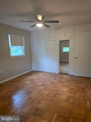 a view of an empty room with closet and a window