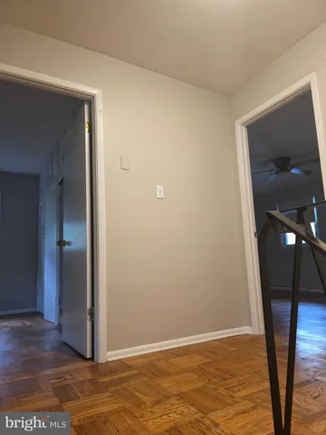 a view of an empty room with wooden floor and a cabinet