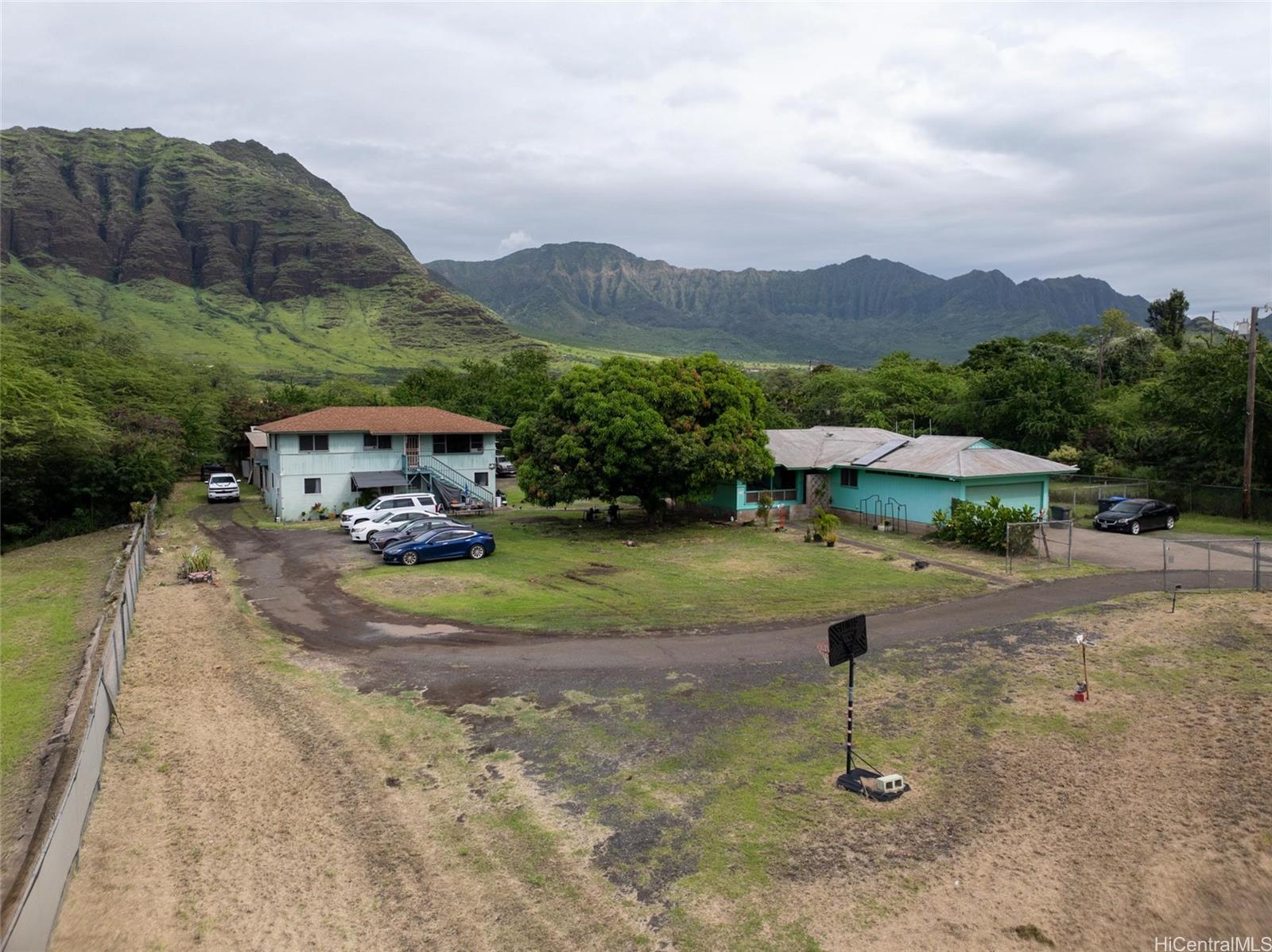85-576 Waianae Valley Road, Unit A Waianae, HI 96792 - Photo 2 of 20 Both single family detached homes comes with the sale of property. Main home on the right is a 3 bedroom, 2 full bath detached home w/enclosed garage. 2-story home comes with a 3 bedroom 1 full bath upstairs and downstairs come with a 1 bedroom, 1 full bath, living room, kitchen, covered patio for entertaining guests.