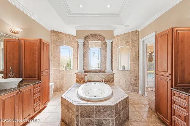 a spacious bathroom with a double vanity sink a mirror a bathtub and window