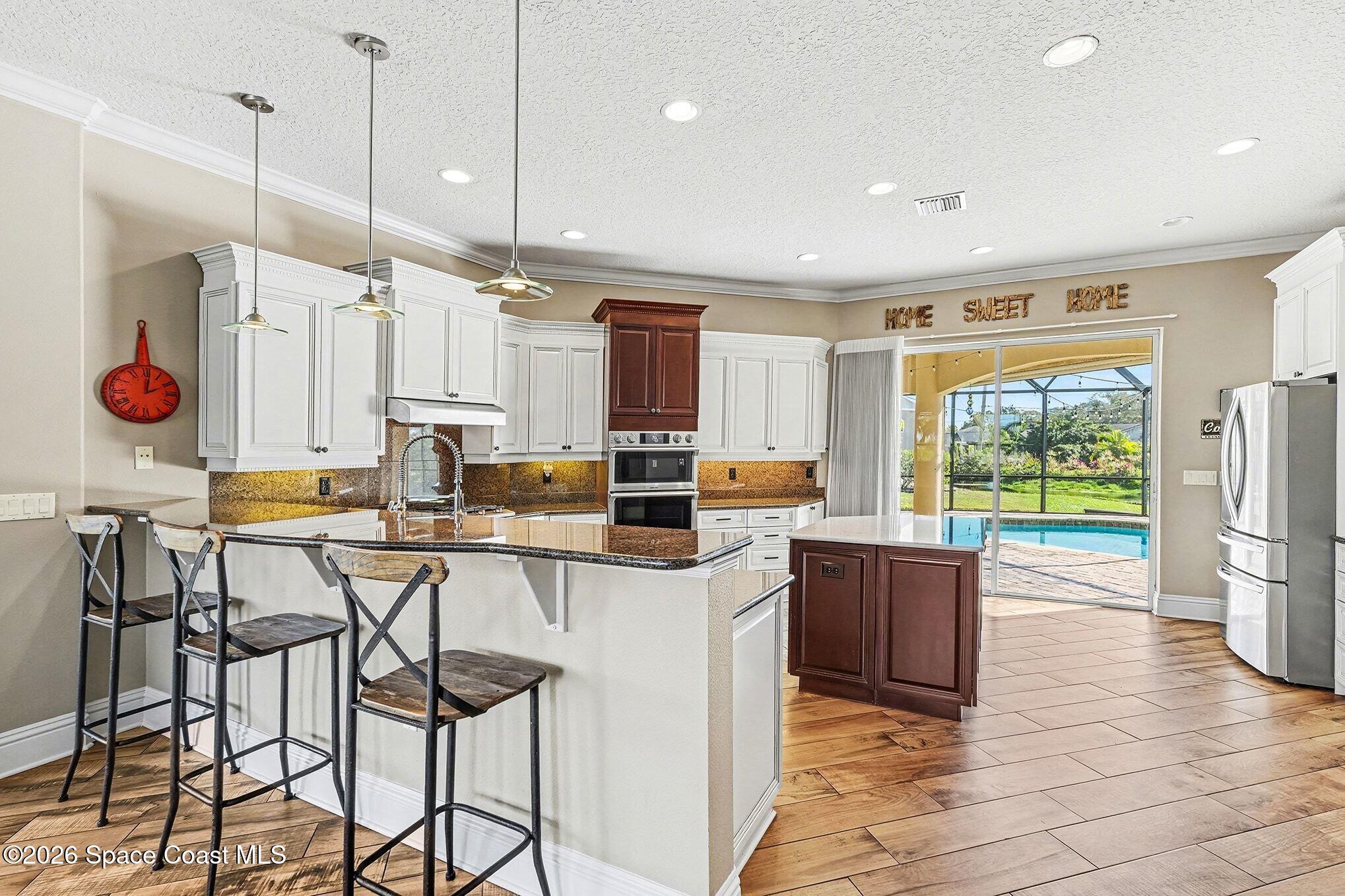 1 Point View Place Cocoa, FL 32926 - Photo 9 of 45 a kitchen with stainless steel appliances kitchen island granite countertop a table chairs and a refrigerator