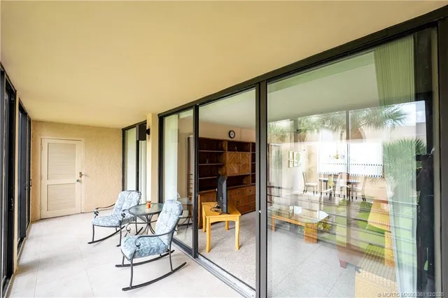 a living room with furniture and a floor to ceiling window