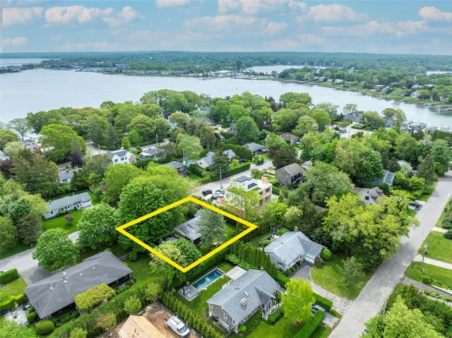 an aerial view of a residential houses with outdoor space and lake view