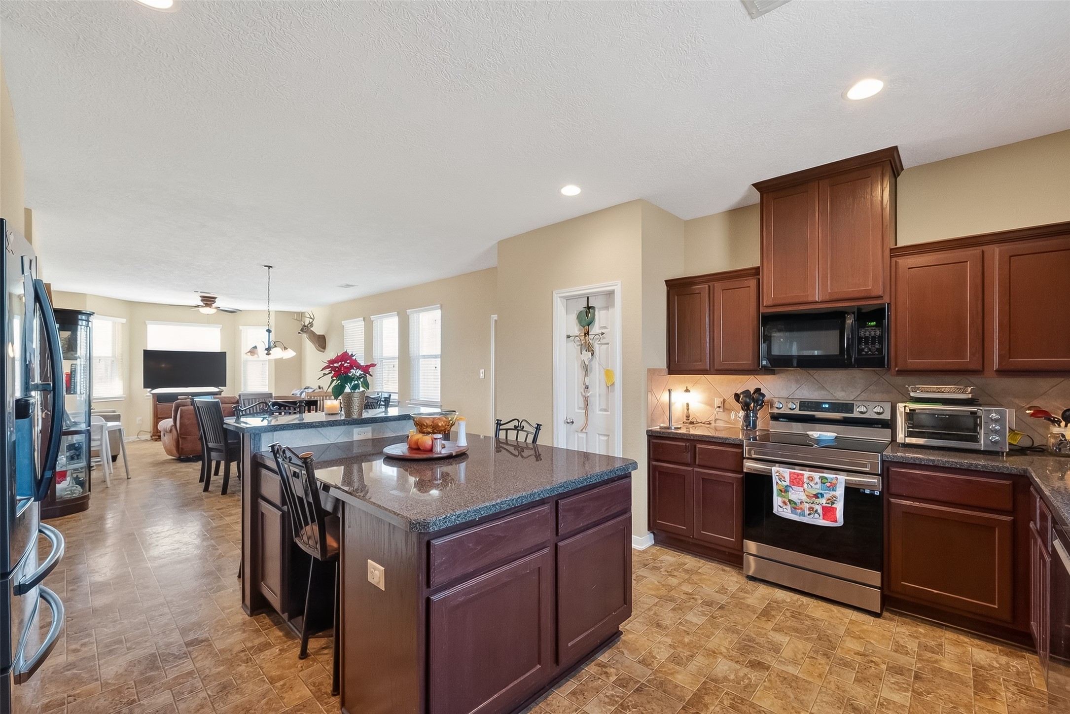 3418 Barbers Hill Road Highlands, TX 77562 - Photo 23 of 50 a kitchen with stainless steel appliances granite countertop a stove top oven a sink dishwasher a dining table and chairs