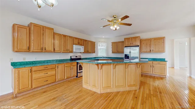 a kitchen with stainless steel appliances granite countertop a sink a stove cabinets and wooden floor