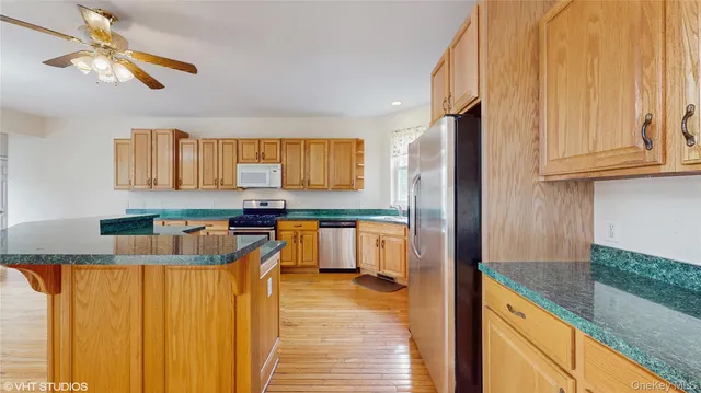 a kitchen with granite countertop a refrigerator a stove and a sink