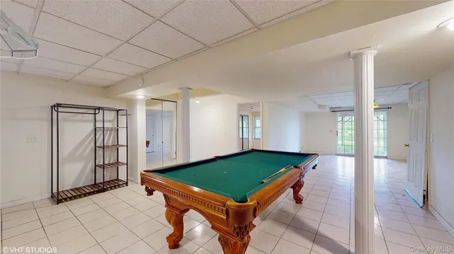 a room with pool table and large window