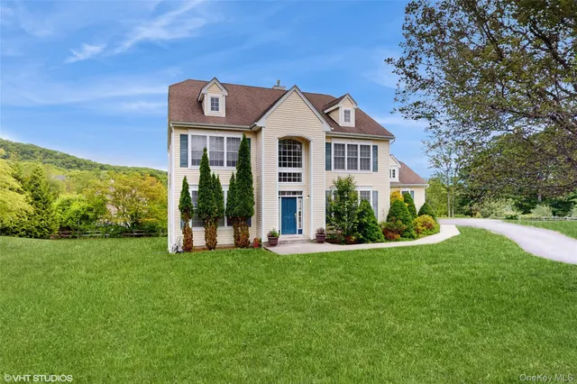 a view of a big house with a big yard and large trees