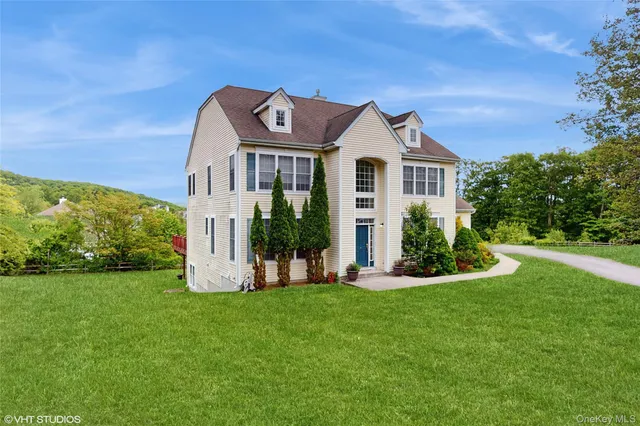 a front view of a house with a yard and trees